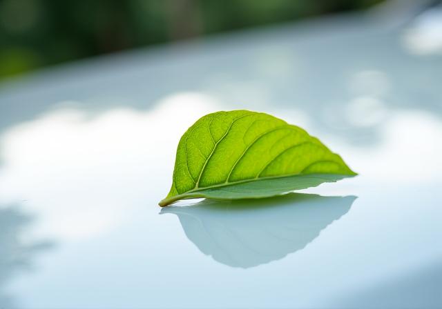 Símbolo de movilidad sostenible con una hoja verde sobre un coche
